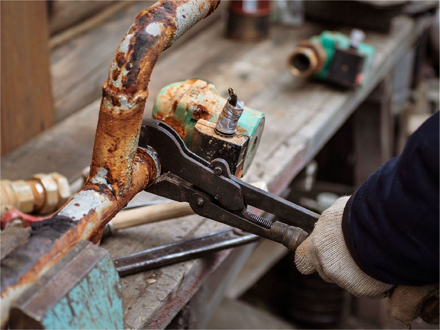 Plumber inspecting an aging copper supply line for pitting corrosion and recurring pinhole leaks in a Coppell home