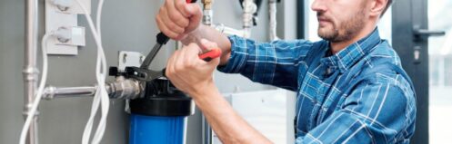 Plumber installing a whole house water filtration system in a Dallas TX home at the main supply line.
