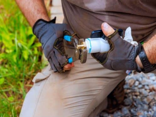 Plumber performing water line repair in Dallas TX on a corroded residential pipe at the main supply connection.